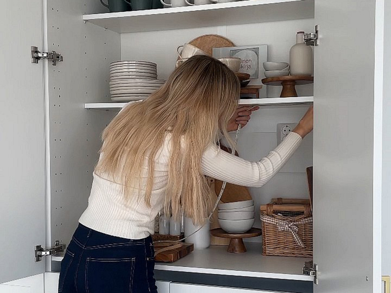 Woman installing an LED strip in a breakfast cupboard