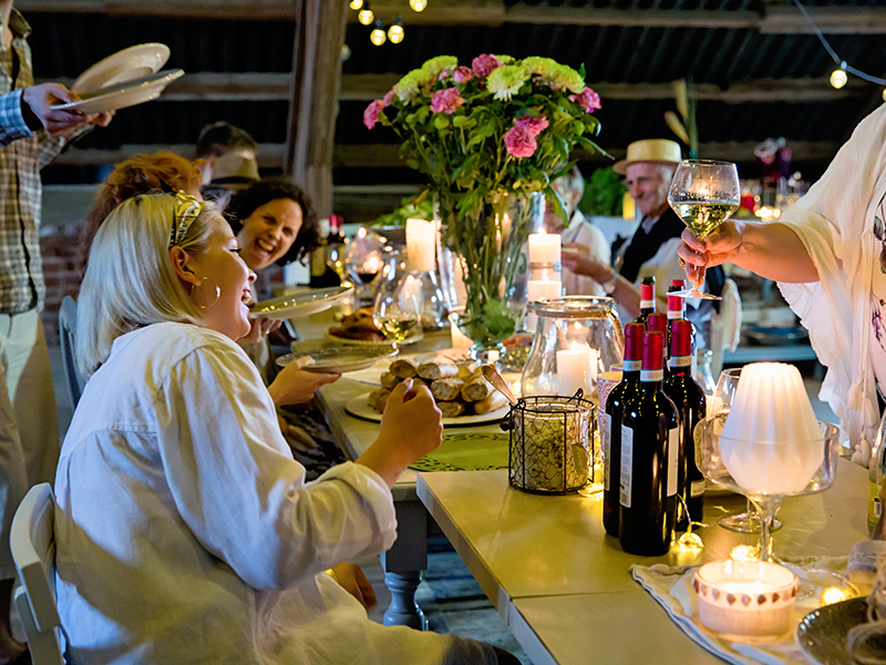 Venetian summer party with happy people gathered around a dining table
